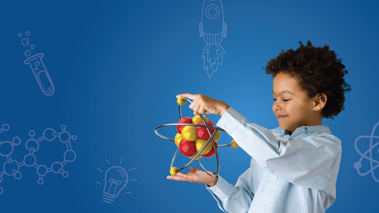 Boy in a lab coat holding an atom