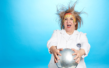Mad scientist touching a van der graaf causing her hair to rise.